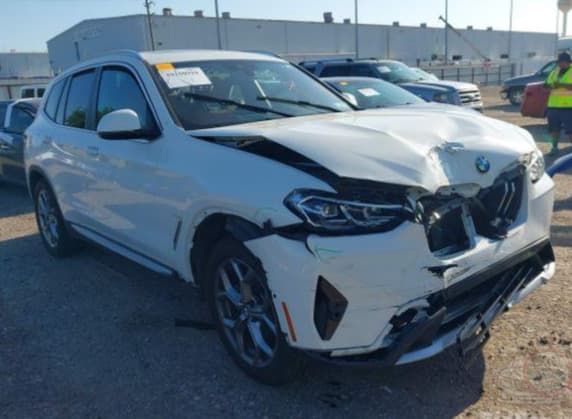 The same 2023 BMW X3 in the salvage auction lane with front-end collision damage