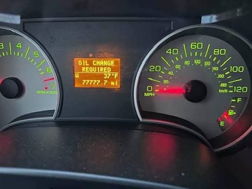 Oil-change sticker showing higher mileage than the cluster